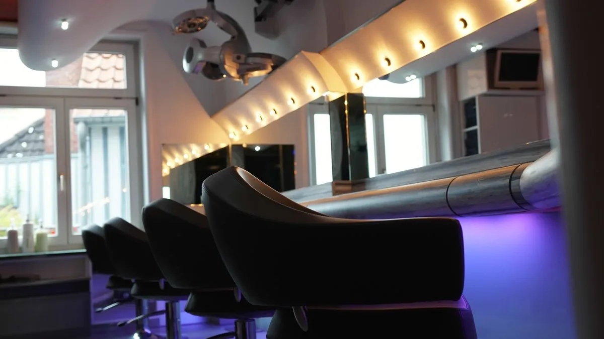 Friseurstühle vor der beleuchteten Spiegelwand bei Boris Reinert HAIR